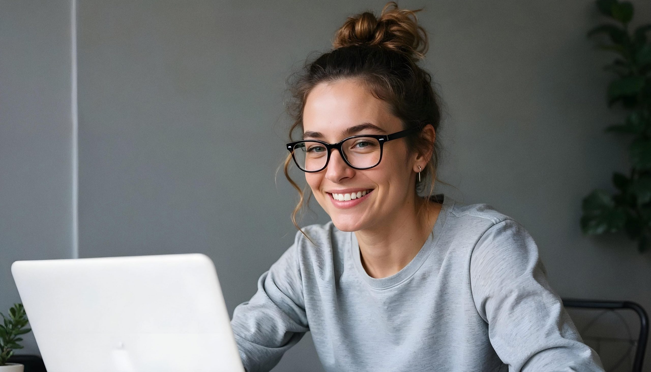 Chica sonriendo delante de ordenador realizando una formación online